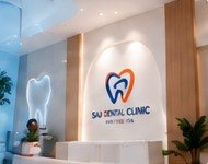 Reception area of SAJ Dental Clinic with the illuminated clinic logo and a glowing tooth sign