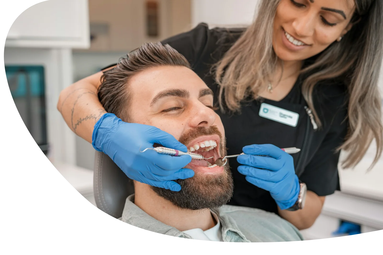 Dentist gently treating a relaxed patient in the dental chair