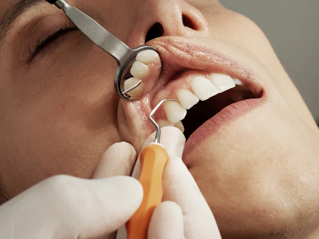 Dentist carefully examining a patient’s teeth with a mirror and probe